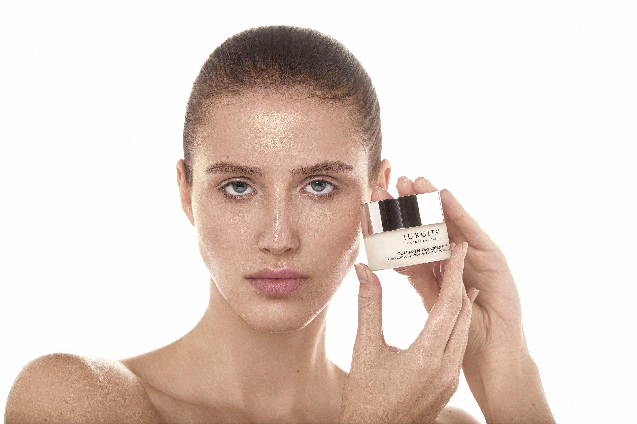 A model with radiant skin holding the Jurgita Cosmeceuticals Collagen Day Cream SPF 50, showcasing its hydrating and anti-aging benefits.
