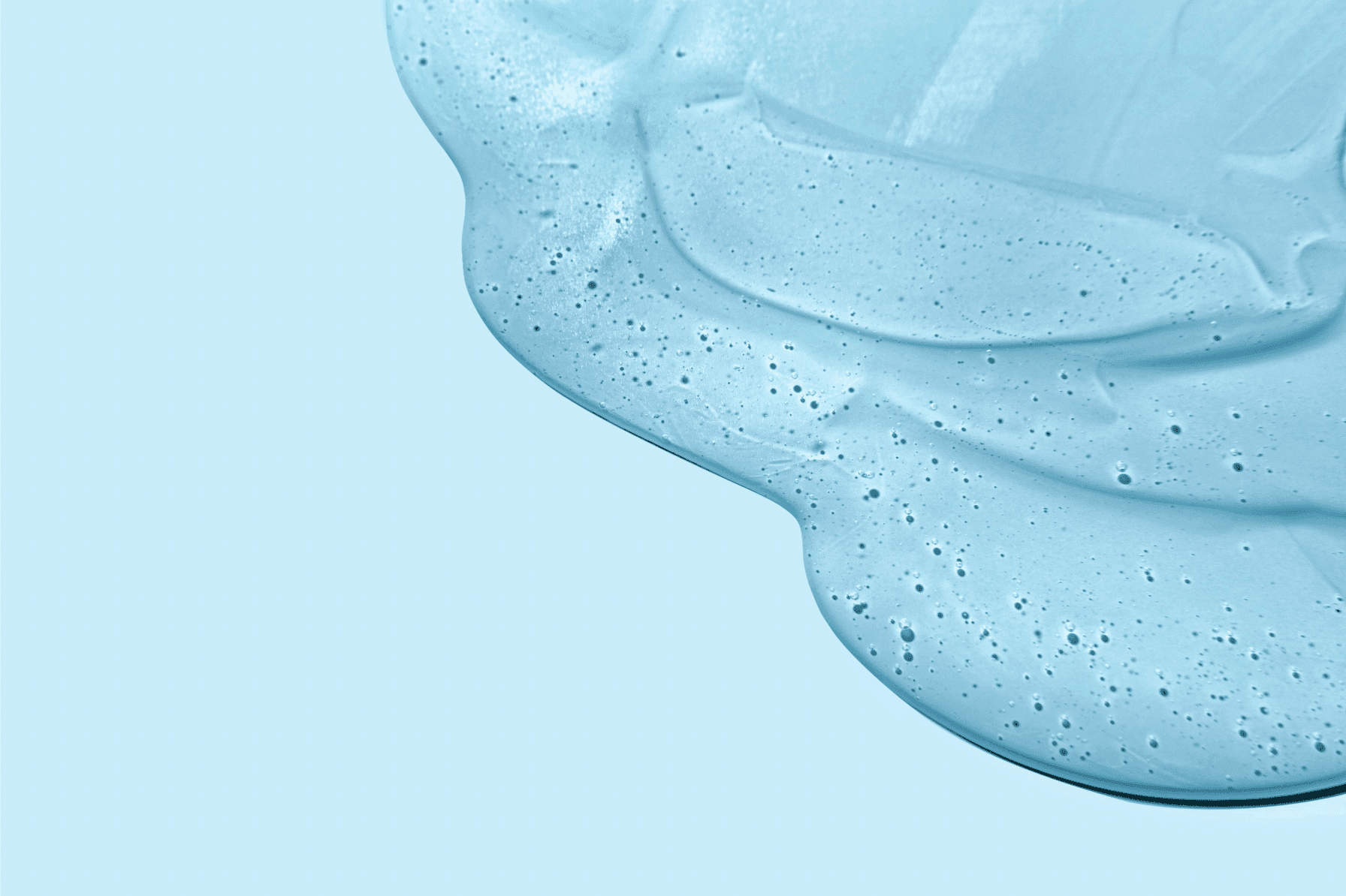 A smooth, cooling blue serum texture with tiny bubbles, representing the lightweight, fast-absorbing formula of the Jurgita Cosmeceuticals Reshape & Detox Body Serum.