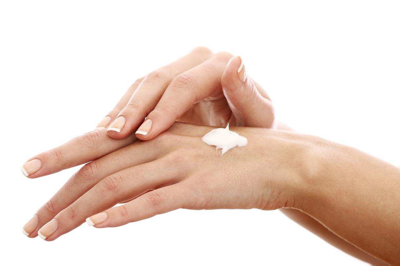 A close-up of well-manicured hands with a dollop of Jurgita Cosmeceuticals Prime Hand Cream, showcasing its rich and hydrating texture.
