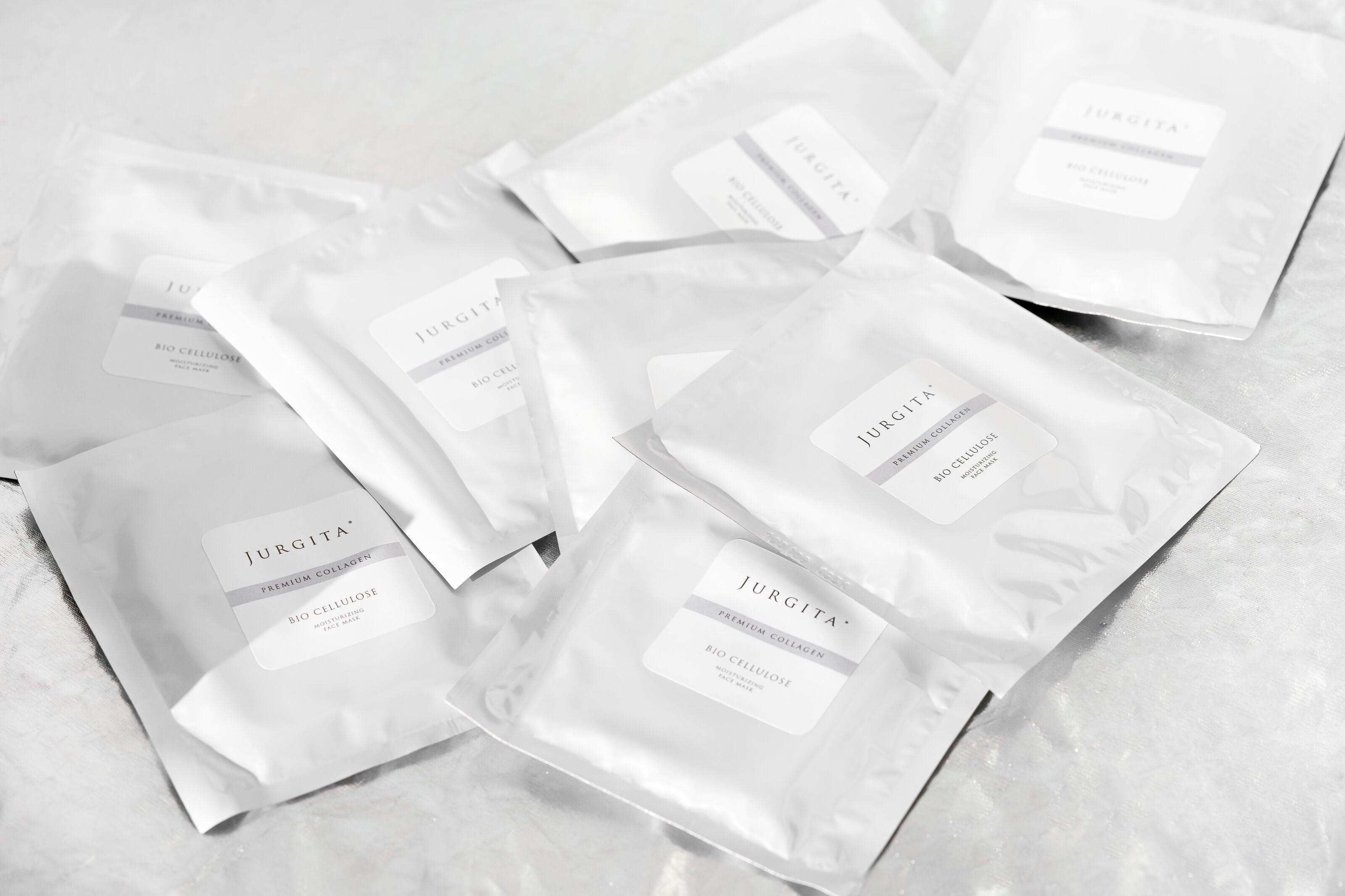 Jurgita Cosmeceuticals Bio-Cellulose Face Mask sachets displayed in a flat lay, emphasizing the professional-quality hydration treatment.