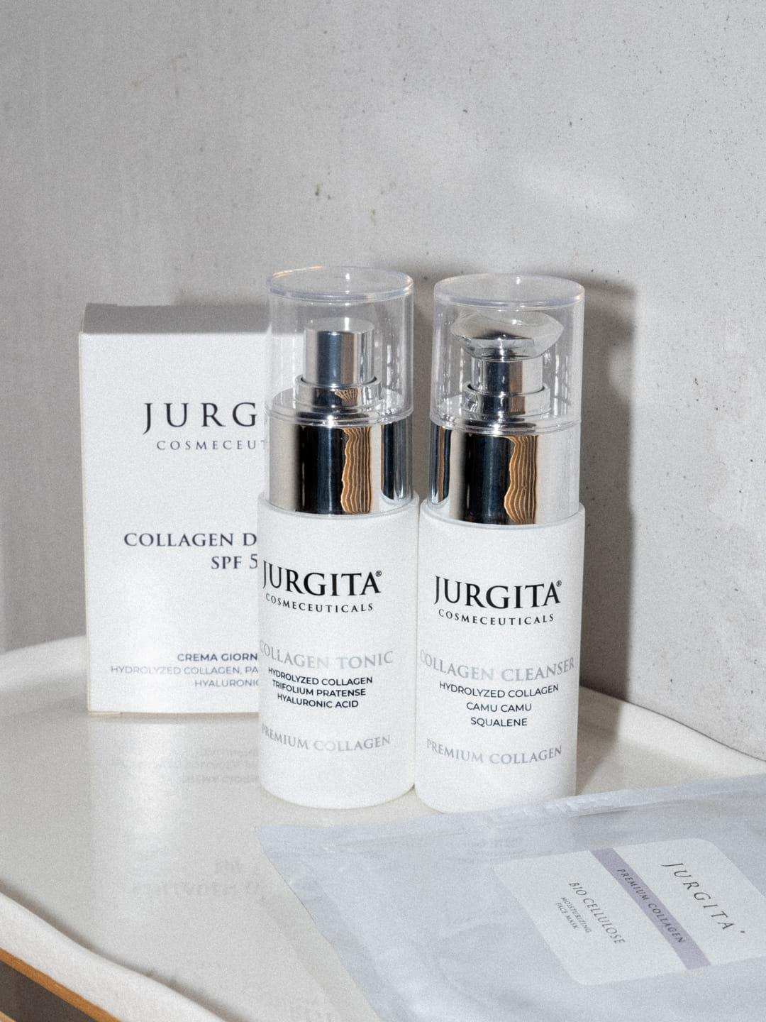Jurgita Cosmeceuticals Collagen Cleanser and Collagen Tonic in sleek white bottles with silver pump tops, displayed alongside the SPF 50 Collagen Day Cream and Bio-Cellulose Face Mask.