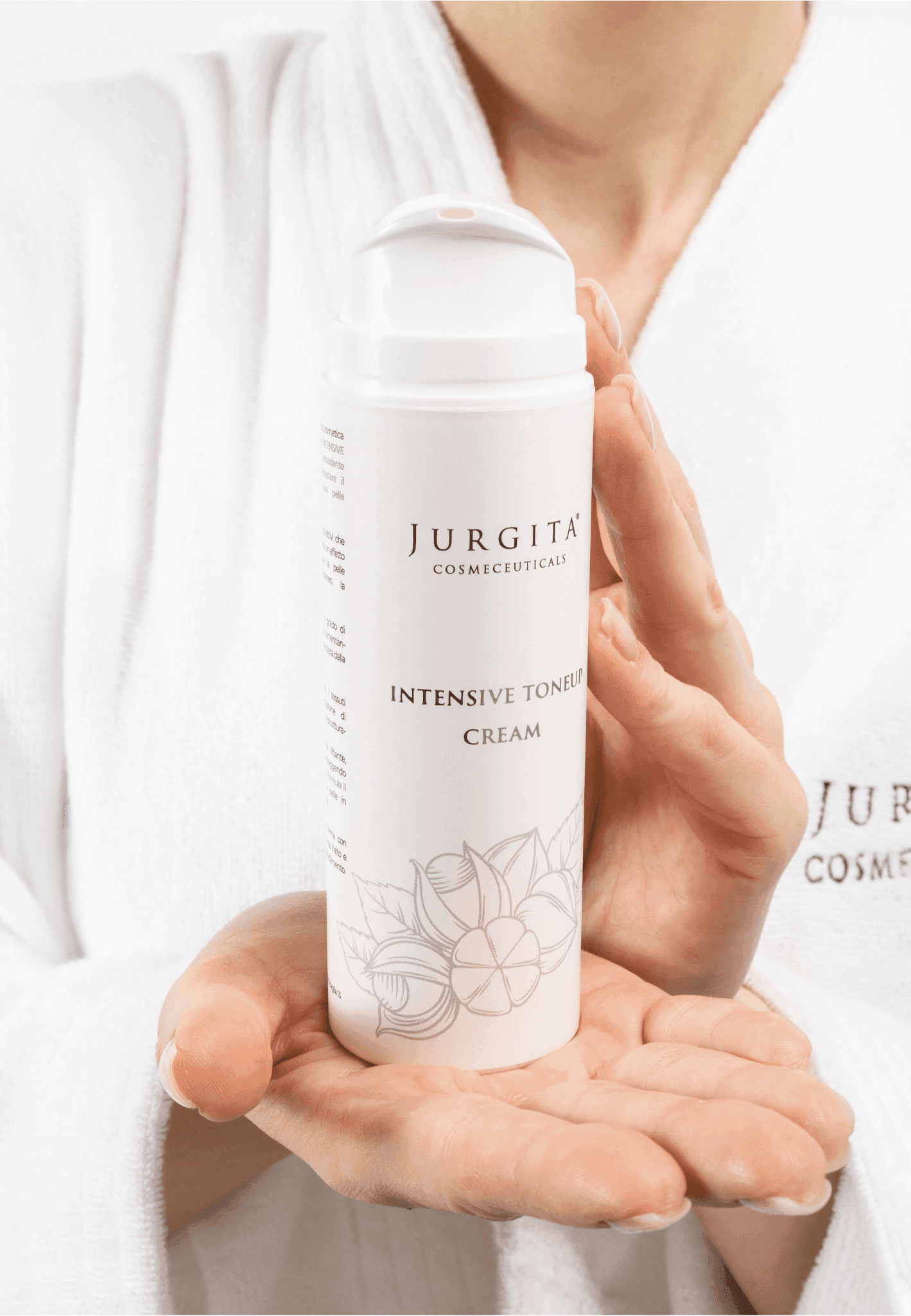 A woman in a white robe holding the Jurgita Cosmeceuticals Intensive Tone Up Cream, emphasizing its luxurious, skin-tightening benefits.