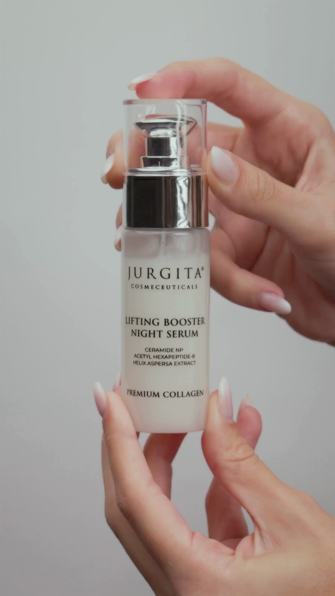 A close-up video showing the silky-smooth texture of the Jurgita Lifting Booster Night Serum as it glides onto the skin. A model applies the serum, demonstrating its lightweight, fast-absorbing consistency and hydration effects.