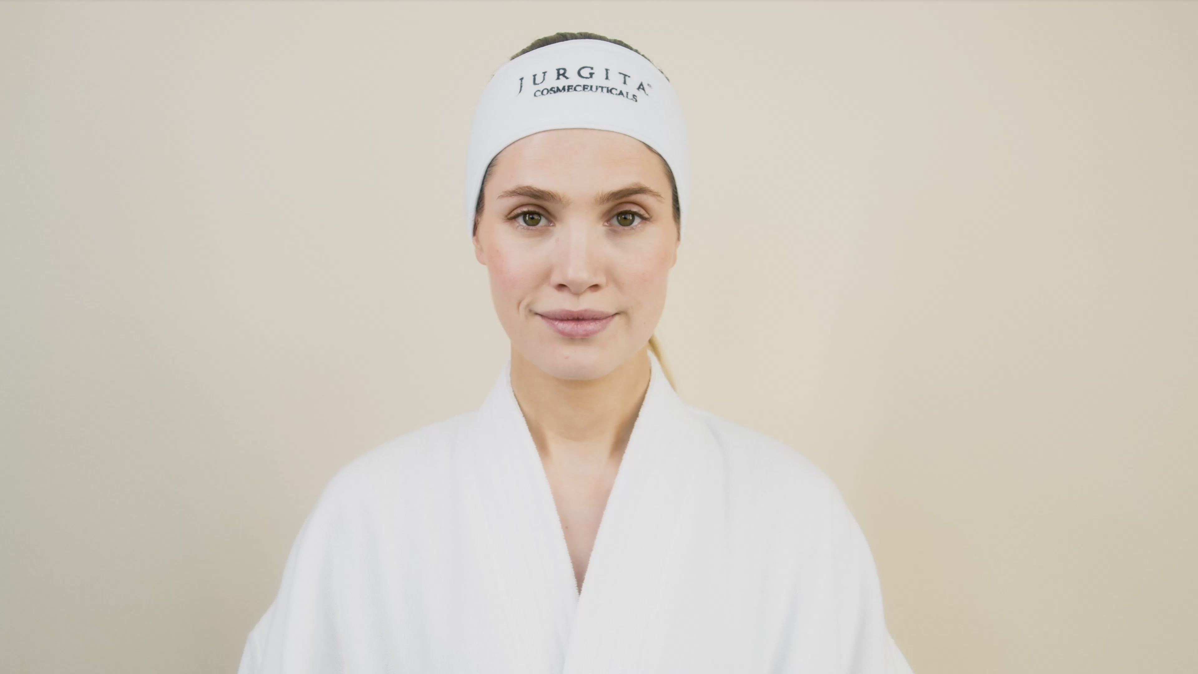 A model applying Jurgita Cosmeceuticals Collagen Day Cream SPF 50, demonstrating its smooth texture and deep moisturizing effect for daily skin defense.
