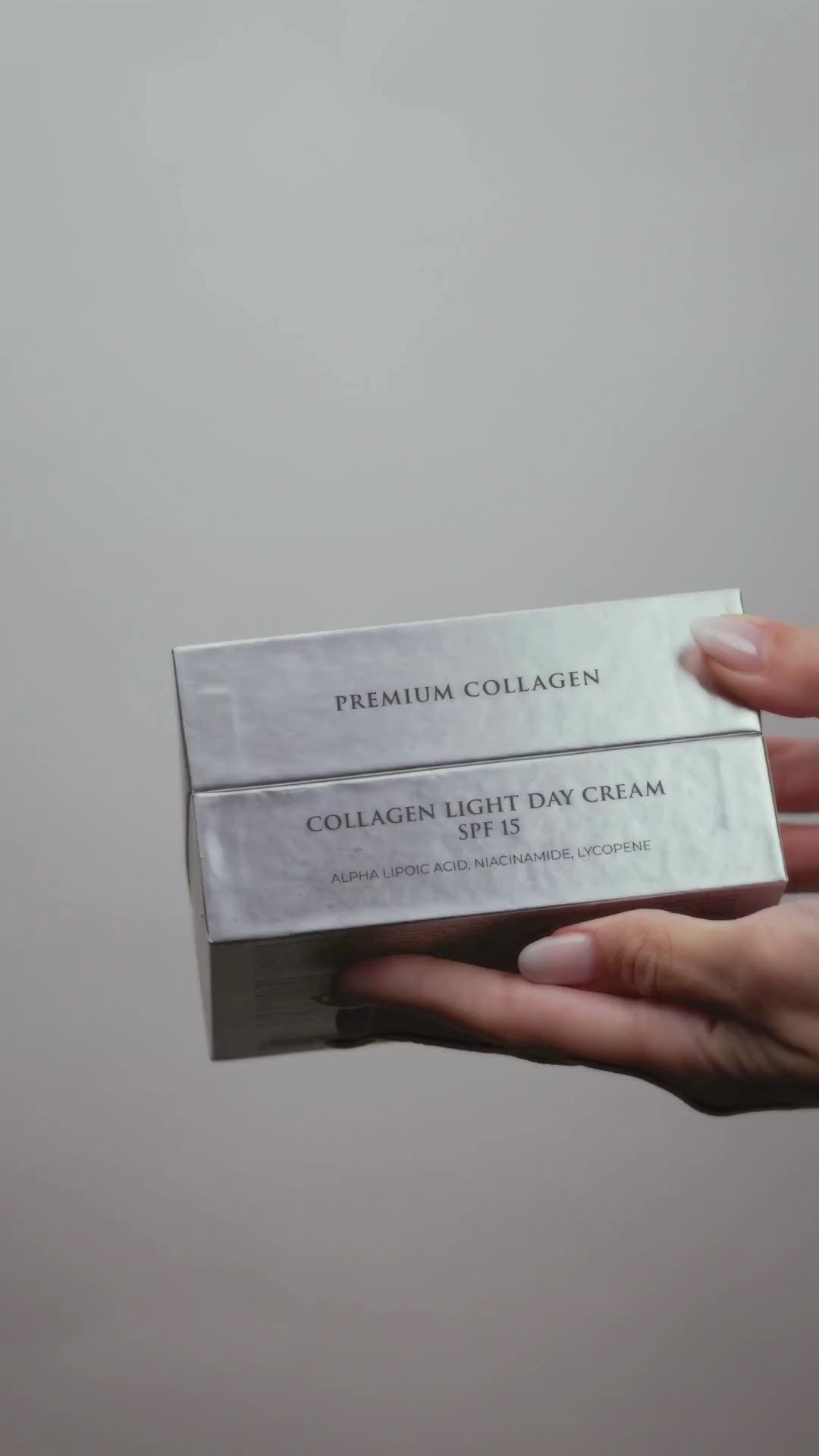 A close-up of hands elegantly unboxing Jurgita Cosmeceuticals Collagen Light Day Cream SPF 15, showcasing the jar and applying a small amount to the skin in a smooth demo