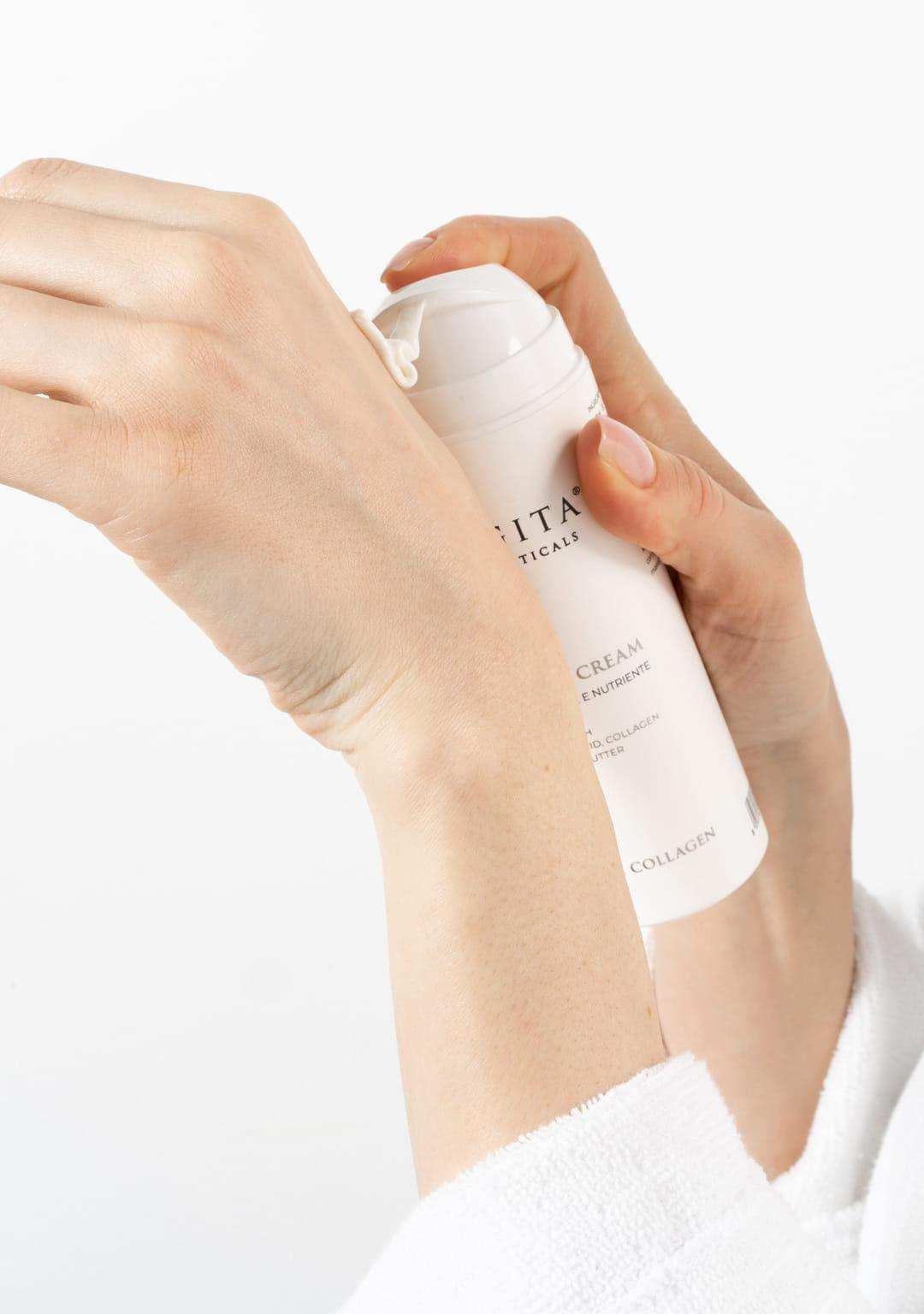 A woman in a plush white robe holding the Jurgita Cosmeceuticals Silk Body Cream, showcasing its lightweight texture and deeply moisturizing properties.