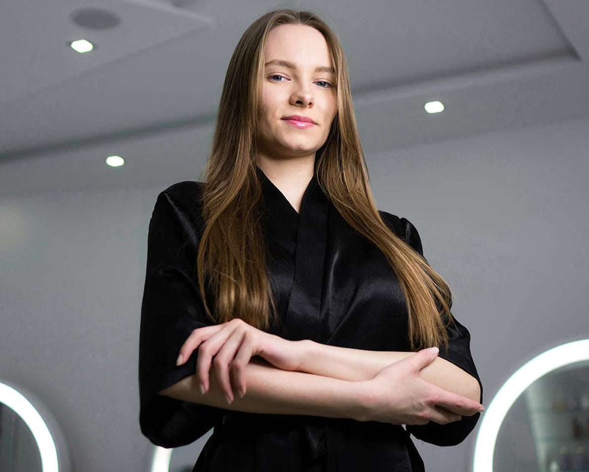 Confident beauty professional in a sleek black robe, representing expert support for the Jurgita Cosmeceuticals Perfect Body treatments.