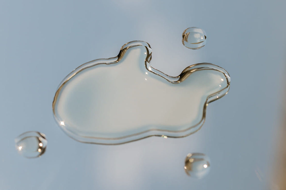 Close-up of a skincare serum drop on glass, symbolizing purity, hydration, and the radiant glow of well-nurtured skin.